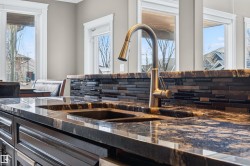 Dual undermount sinks with a high-arc faucet set into a polished countertop - 
