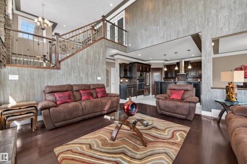 Two-story living area featuring dark wood-finish flooring and a stone-clad fireplace - 1254 Adamson Drive, Edmonton, AB - Indoor Photo Showing Living Room