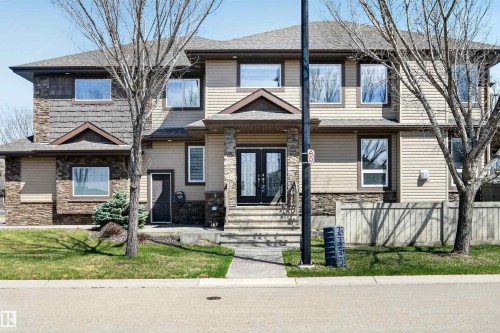 Multi-level residence featuring a stone and siding exterior, prominent front entry with double doors, and a concrete walkway - 1254 Adamson Drive, Edmonton, AB - Outdoor With Facade