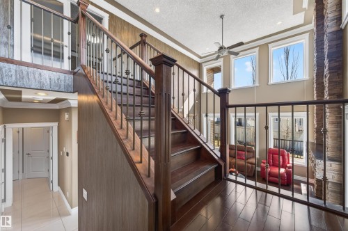 Wood-finish staircase with wrought iron spindles and dark wood banisters - 1254 Adamson Drive, Edmonton, AB - Indoor Photo Showing Other Room