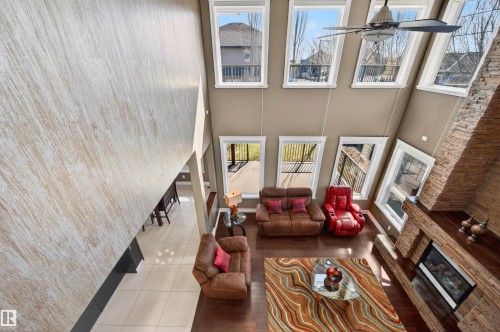 Two-story living area with a stone-clad fireplace and hearth - 1254 Adamson Drive, Edmonton, AB - Indoor Photo Showing Other Room