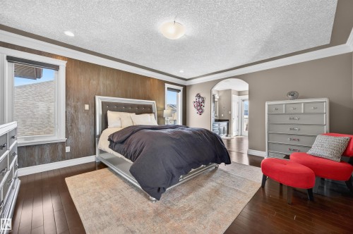 Hardwood flooring throughout this room featuring a decorative accent wall - 1254 Adamson Drive, Edmonton, AB - Indoor Photo Showing Bedroom
