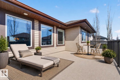 Expansive outdoor deck featuring a concrete surface, black metal railing, and brown siding exterior - 1254 Adamson Drive, Edmonton, AB - Outdoor With Deck Patio Veranda