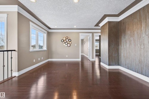 Spacious room featuring rich wood-finish flooring, white crown molding, and recessed lighting - 1254 Adamson Drive, Edmonton, AB - Indoor Photo Showing Other Room