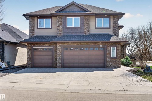 Two-story residence featuring a stone and siding exterior with a dark shingle roof - 1254 Adamson Drive, Edmonton, AB - Outdoor With Facade
