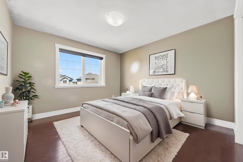 Bedroom featuring rich wood-finish flooring, a contemporary window with white trim, a flush-mount ceiling light fixture, and neutral-toned walls - 1254 Adamson Drive, Edmonton, AB - Indoor Photo Showing Bedroom
