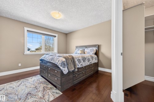 Hardwood-finish flooring, neutral wall paint, and a large window with white trim - 1254 Adamson Drive, Edmonton, AB - Indoor Photo Showing Bedroom