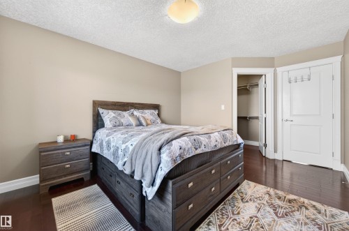 Bedroom featuring rich wood-finish flooring, light neutral-toned walls, and a recessed ceiling light fixture - 1254 Adamson Drive, Edmonton, AB - Indoor Photo Showing Bedroom