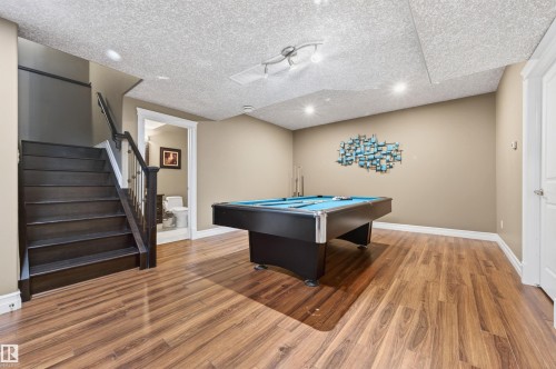 Recreation room featuring wood-finish flooring, recessed lighting, and a dark wood staircase with white risers - 1254 Adamson Drive, Edmonton, AB - Indoor Photo Showing Other Room