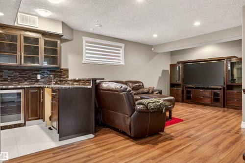 Entertainment area featuring wood-finish flooring, a built-in wet bar with a beverage cooler, and recessed lighting - 1254 Adamson Drive, Edmonton, AB - Indoor Photo Showing Other Room