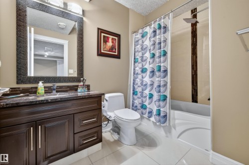 Bathroom featuring a dark wood-finish vanity with a stone-finish countertop and rectangular sink - 1254 Adamson Drive, Edmonton, AB - Indoor Photo Showing Bathroom