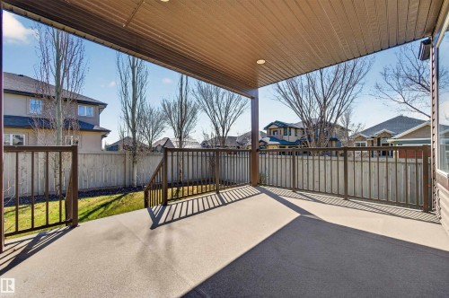 Covered concrete patio with recessed lighting, dark metal railings, and a fenced yard - 1254 Adamson Drive, Edmonton, AB - Outdoor With Deck Patio Veranda With Exterior
