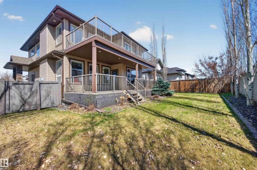 Two-story residence with a covered lower deck and an open upper deck, featuring a fenced backyard with a manicured lawn - 1254 Adamson Drive, Edmonton, AB - Outdoor With Deck Patio Veranda