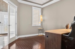 Spacious room with dark wood-finish flooring, light tan walls, and a window featuring horizontal blinds - 