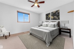 Bedroom featuring light-colored carpeting, a brown wood-finish window frame, and a ceiling fan with dark wood-finish blades - 