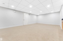 Spacious room featuring neutral carpeting, recessed lighting, and a drop ceiling - 