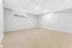 Finished room featuring light beige carpeting, white walls, and a drop ceiling with recessed lighting - 