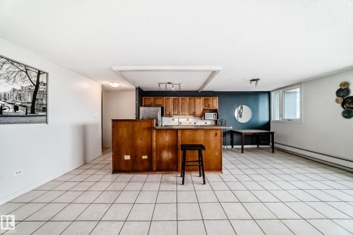 Open-concept living area with light-toned tile flooring throughout - 405 10135 Saskatchewan Drive Nw, Edmonton, AB - Indoor Photo Showing Other Room