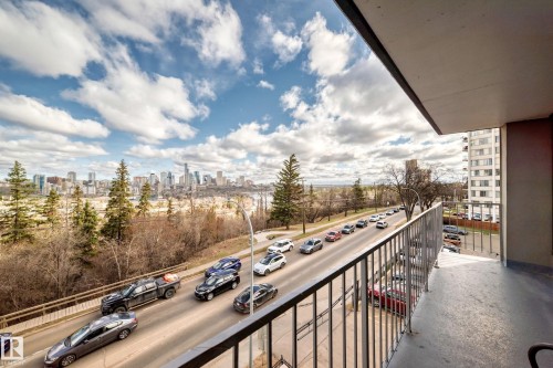 Balcony featuring a metal railing system, concrete flooring, and an urban skyline backdrop - 405 10135 Saskatchewan Drive Nw, Edmonton, AB - Outdoor With View