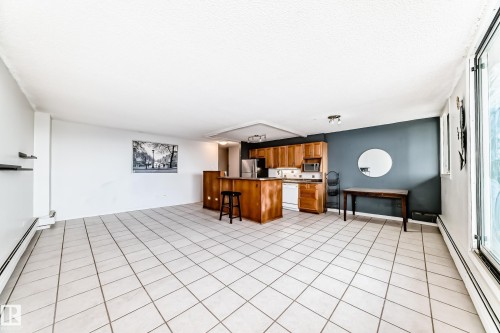 Open-concept living area featuring light-toned square tile flooring throughout - 405 10135 Saskatchewan Drive Nw, Edmonton, AB - Indoor