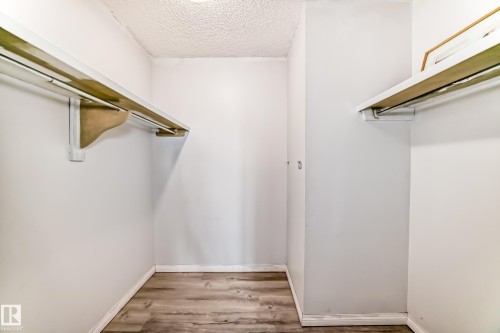 Wardrobe space featuring wood-finish flooring and a textured ceiling - 405 10135 Saskatchewan Drive Nw, Edmonton, AB - Indoor With Storage