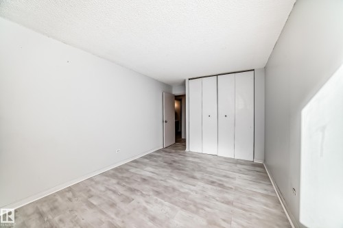Room featuring wood-finish flooring, light grey painted walls, and white trim - 405 10135 Saskatchewan Drive Nw, Edmonton, AB - Indoor Photo Showing Other Room
