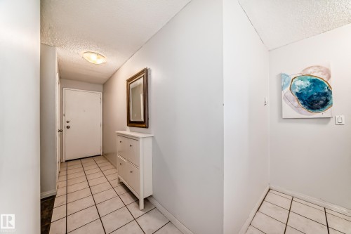Entryway featuring light-toned tile flooring, neutral wall finishes, and a flush-mount ceiling light fixture - 405 10135 Saskatchewan Drive Nw, Edmonton, AB - Indoor Photo Showing Other Room