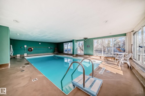 Indoor swimming pool featuring an aquatic ladder, concrete flooring, recessed lighting, and large windows offering exterior views - 405 10135 Saskatchewan Drive Nw, Edmonton, AB - Indoor Photo Showing Other Room With In Ground Pool