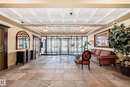 Expansive tiled entryway featuring a coffered ceiling, recessed lighting, and glass double-doors - 405 10135 Saskatchewan Drive Nw, Edmonton, AB - Indoor Photo Showing Other Room