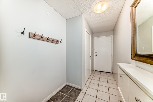 Entryway featuring light-toned walls, white trim, and a combination of square tiled flooring - 405 10135 Saskatchewan Drive Nw, Edmonton, AB - Indoor