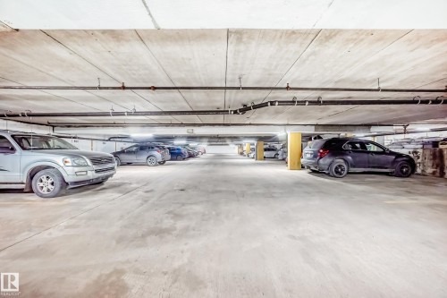 Dedicated underground parking space featuring concrete flooring and ceiling, exposed pipework, and structural columns - 405 10135 Saskatchewan Drive Nw, Edmonton, AB - Indoor Photo Showing Garage