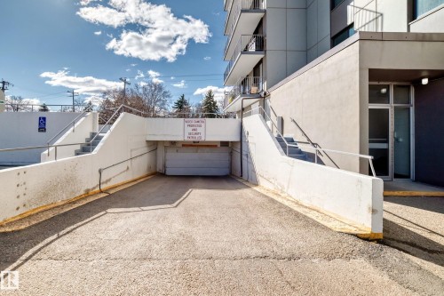 Underground parking garage entrance featuring a concrete driveway and adjacent stair access - 405 10135 Saskatchewan Drive Nw, Edmonton, AB - Outdoor