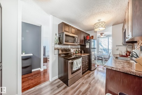 Kitchen with wood-finish flooring and dark wood cabinetry - 601 10135 Saskatchewan Drive Nw, Edmonton, AB - Indoor Photo Showing Kitchen