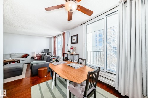 Open-concept living space featuring wood-finish flooring and a ceiling fan - 601 10135 Saskatchewan Drive Nw, Edmonton, AB - Indoor