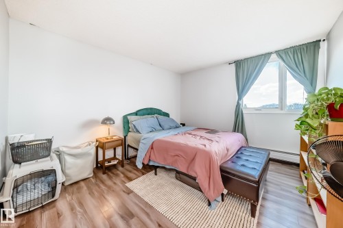 Bedroom featuring wood-finish flooring, a window with natural light, and a built-in heating element - 601 10135 Saskatchewan Drive Nw, Edmonton, AB - Indoor Photo Showing Bedroom