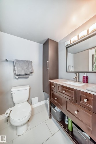 Modern bathroom featuring a dark wood-finish vanity with an integrated sink and light-toned countertop - 601 10135 Saskatchewan Drive Nw, Edmonton, AB - Indoor Photo Showing Bathroom