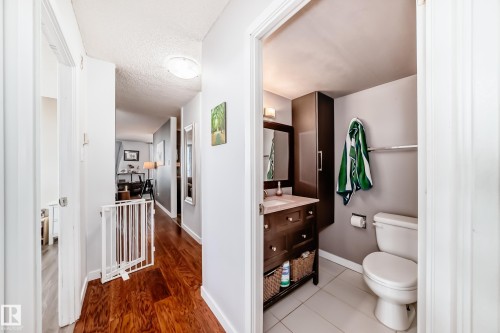 Compact bathroom featuring a dark wood-finish vanity with a light-colored countertop, a wall-mounted medicine cabinet, and light-toned floor tiling - 601 10135 Saskatchewan Drive Nw, Edmonton, AB - Indoor Photo Showing Bathroom