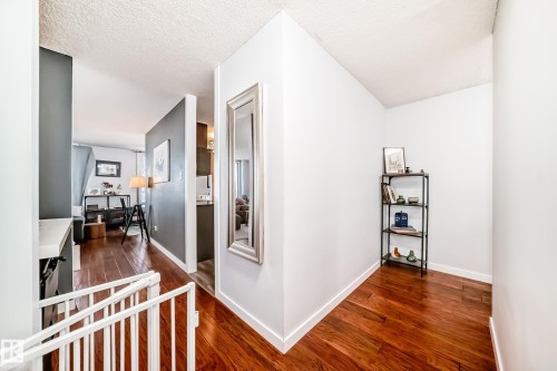 Wood-finish flooring throughout, featuring a bright entryway with white walls and baseboards - 601 10135 Saskatchewan Drive Nw, Edmonton, AB - Indoor Photo Showing Other Room