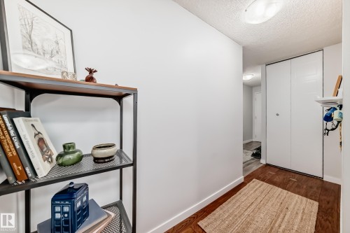 Entryway featuring wood-finish flooring, white baseboards, and a bi-fold closet - 601 10135 Saskatchewan Drive Nw, Edmonton, AB - Indoor Photo Showing Other Room