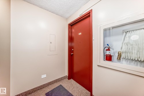 Red entry door with an adjacent fire safety cabinet - 601 10135 Saskatchewan Drive Nw, Edmonton, AB - Indoor Photo Showing Other Room