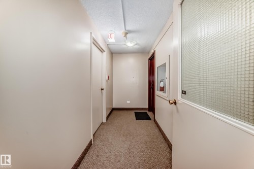 Carpeted corridor with light-toned walls and a textured ceiling - 601 10135 Saskatchewan Drive Nw, Edmonton, AB - Indoor Photo Showing Other Room