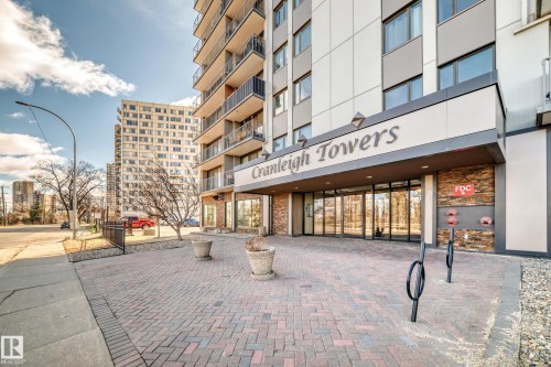 Cranleigh Towers entrance featuring a multi-story facade with balconies, extensive glazing, a brick paver walkway, and stone veneer accents - 601 10135 Saskatchewan Drive Nw, Edmonton, AB - Outdoor