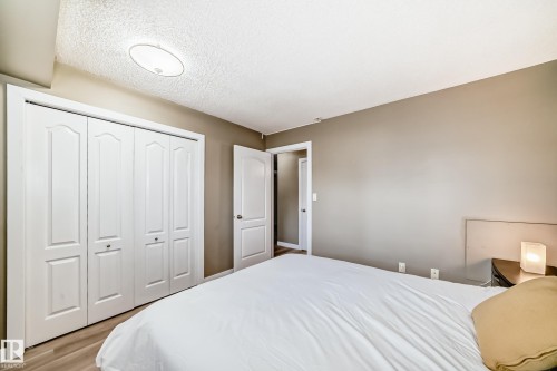 Bedroom featuring wood-finish flooring, neutral wall paint, and a white ceiling with a flush-mount light fixture - 101 10827 85 Avenue Nw, Edmonton, AB - Indoor Photo Showing Bedroom