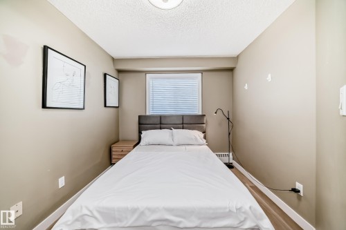 Bedroom featuring neutral wall color, wood-finish flooring, and a window with blinds - 101 10827 85 Avenue Nw, Edmonton, AB - Indoor Photo Showing Bedroom