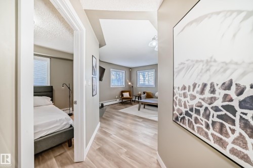 Hallway featuring light wood-finish flooring, neutral wall paint, and white trim - 101 10827 85 Avenue Nw, Edmonton, AB - Indoor Photo Showing Other Room