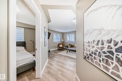 Hallway featuring light wood-finish flooring, neutral wall paint, and white trim - 