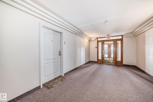 Entry foyer with patterned carpet flooring, white walls, and decorative ceiling trim - 101 10827 85 Avenue Nw, Edmonton, AB - Indoor Photo Showing Other Room
