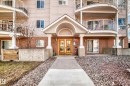 Building exterior featuring brick and siding finishes, a covered entrance with double doors, curved balconies with white railings, and a concrete pathway - 101 10827 85 Avenue Nw, Edmonton, AB  - Outdoor 