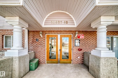 Brick exterior featuring a covered entry with white columns and a textured ceiling - 101 10827 85 Avenue Nw, Edmonton, AB - Outdoor With Exterior