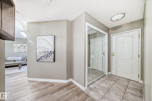 Entryway featuring neutral wall paint, wood-finish flooring, and a tiled landing - 101 10827 85 Avenue Nw, Edmonton, AB - Indoor Photo Showing Other Room